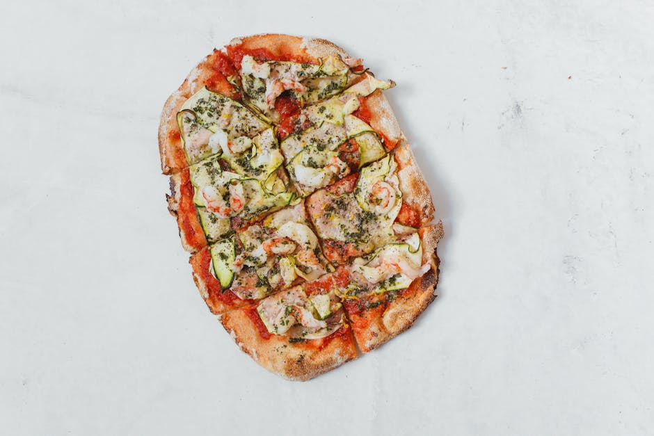 pexels-photo-5848283-5848283 Sliced Italian flatbread pizza topped with cheese, zucchini, and herbs on a white background.