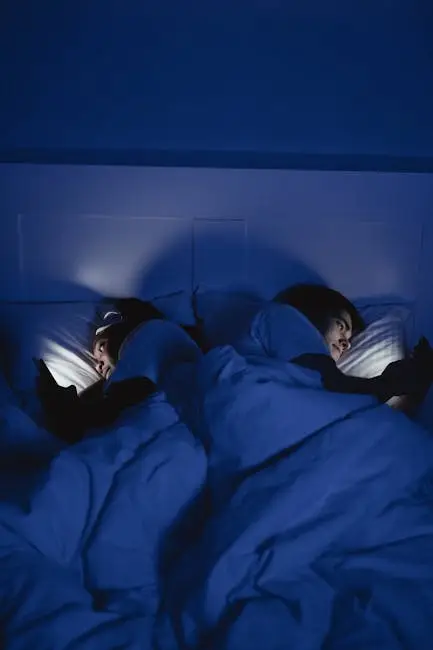 pexels-photo-8036949-8036949 Two people lying in bed under blue light using smartphones, creating a cozy night mood.